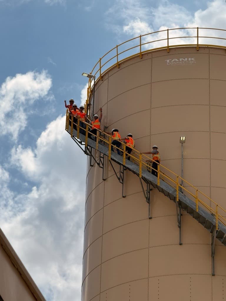 CIG team on tank stairs at a terminal site